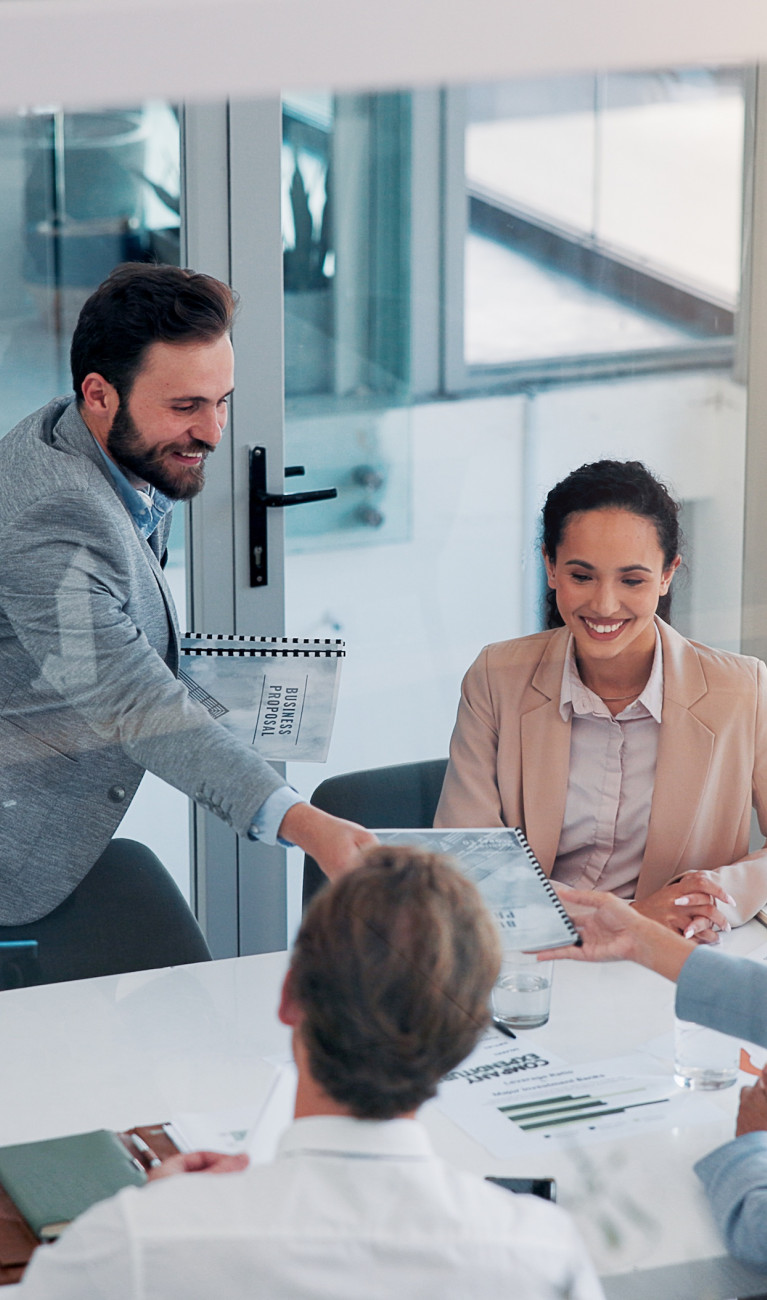 Vier Personen sitzen an einem Tisch und arbeiten