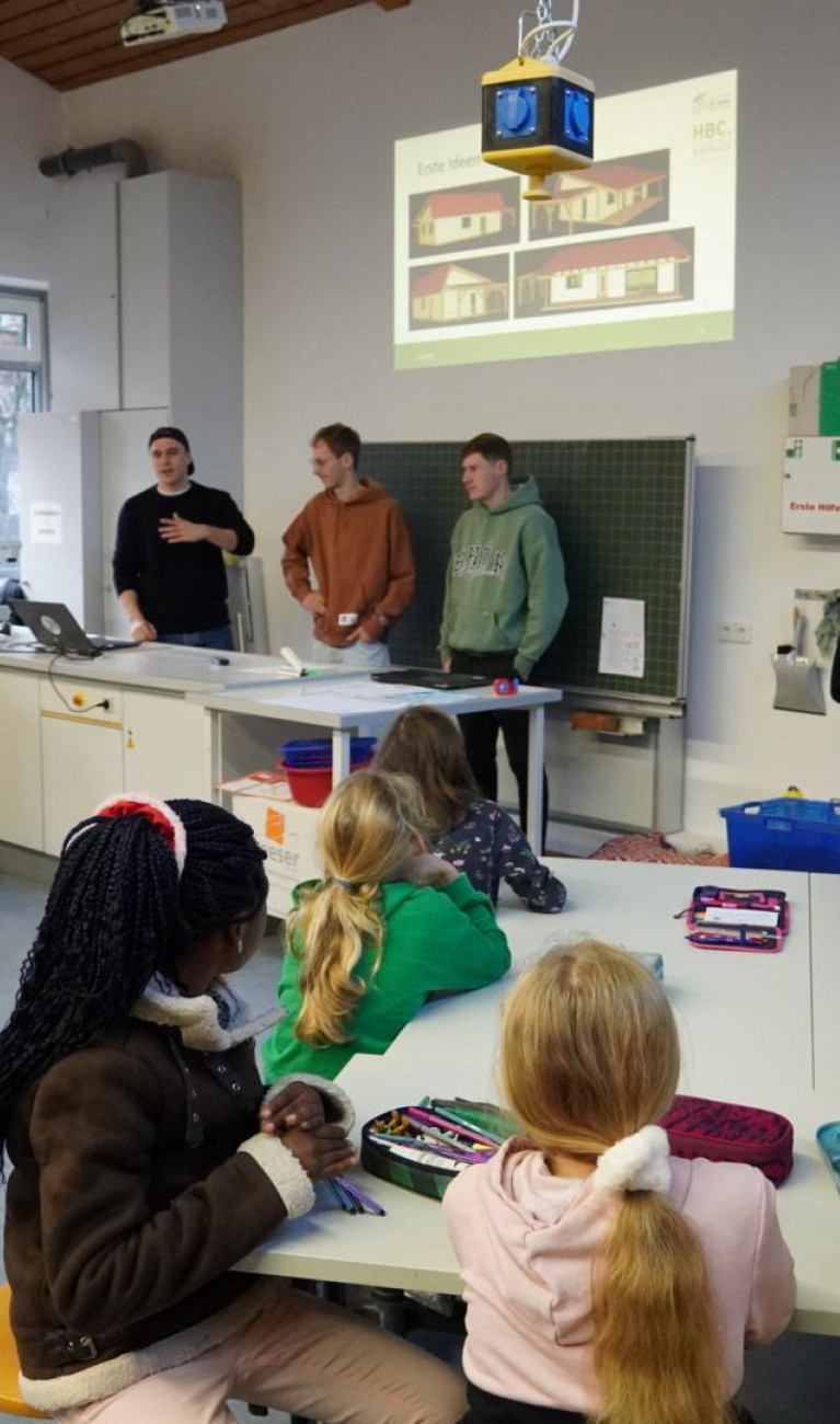 Kinder sitzen in der Schule und planen ein Gebäude