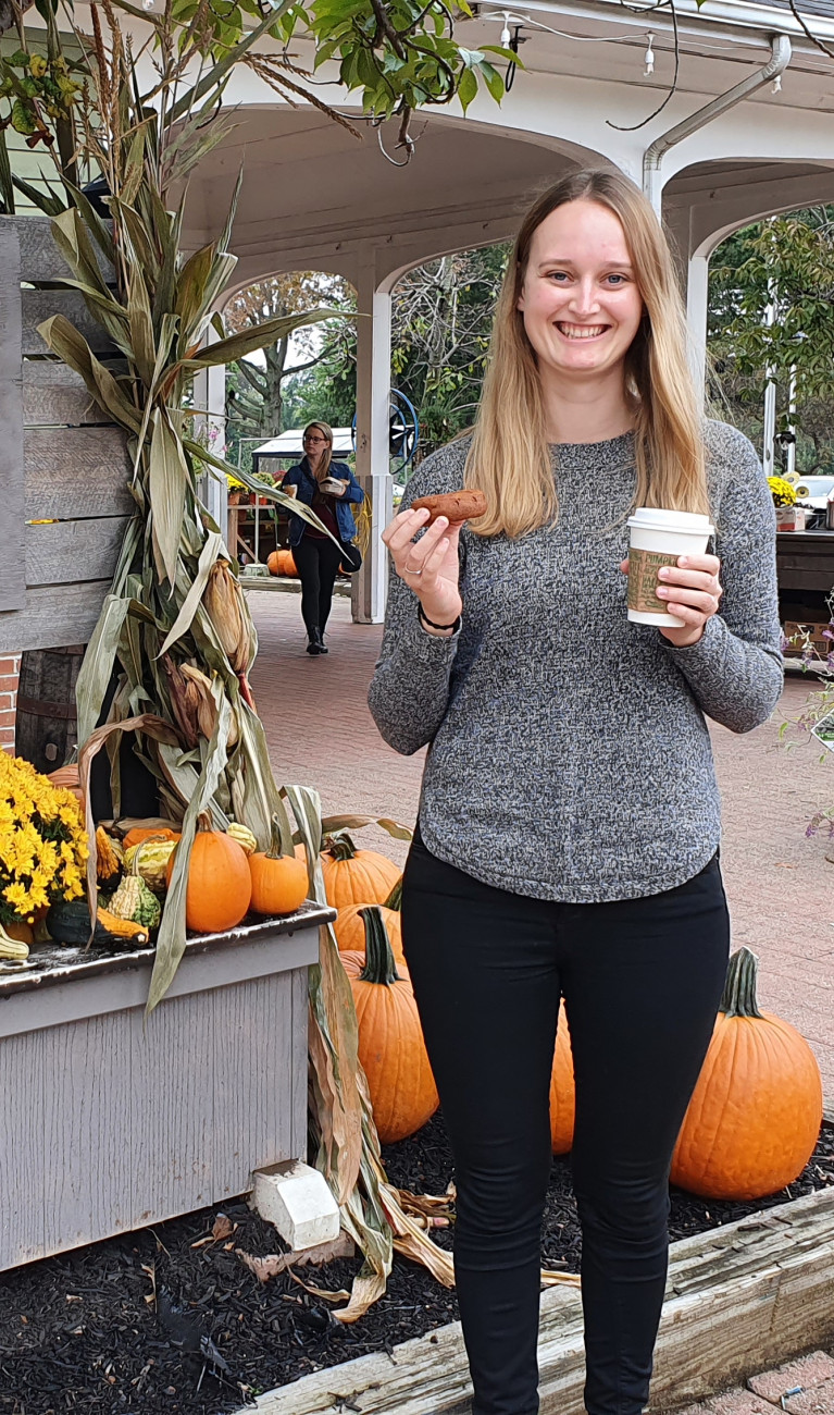 Junge Frau vor einem Kürbisstand in Amerika
