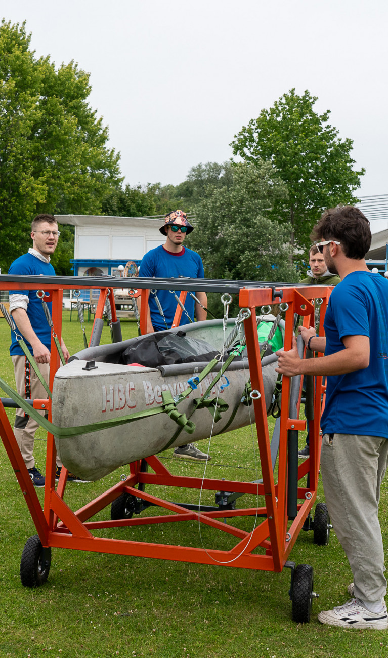 Männer stehen um ein Betonkanu herum