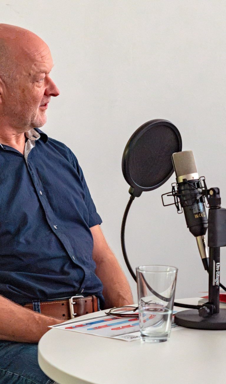 Zwei Personen sitzen bei einer Podcastaufnahme