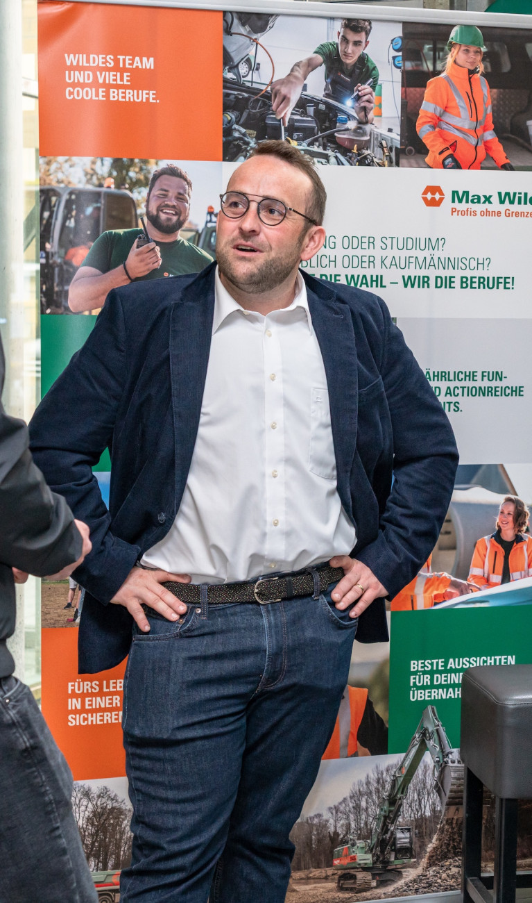 Menschen stehen an einem Messestand und lassen sich beraten 