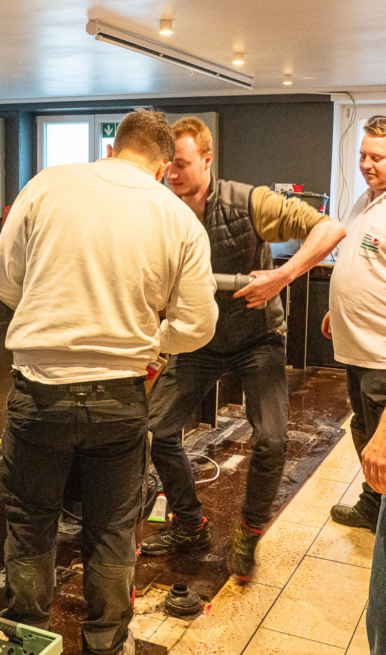 Fünf Männer in einer Kneipe, die die Theke ausbauen