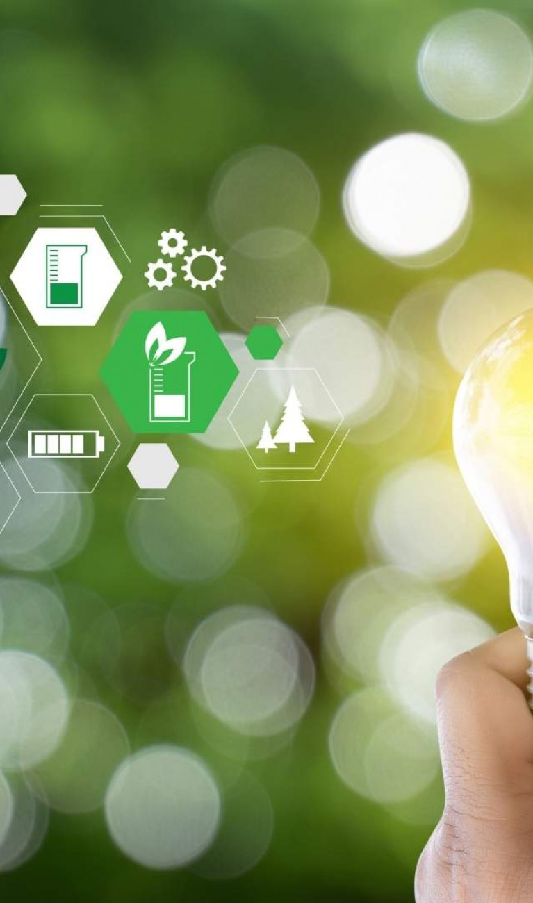 Eine Hand hält eine Glühbirne vor einem grünen Hintergrund, rechts davon sind mehrere kleine Icons rund um das Thema Energie und Nachhaltigkeit zu sehen