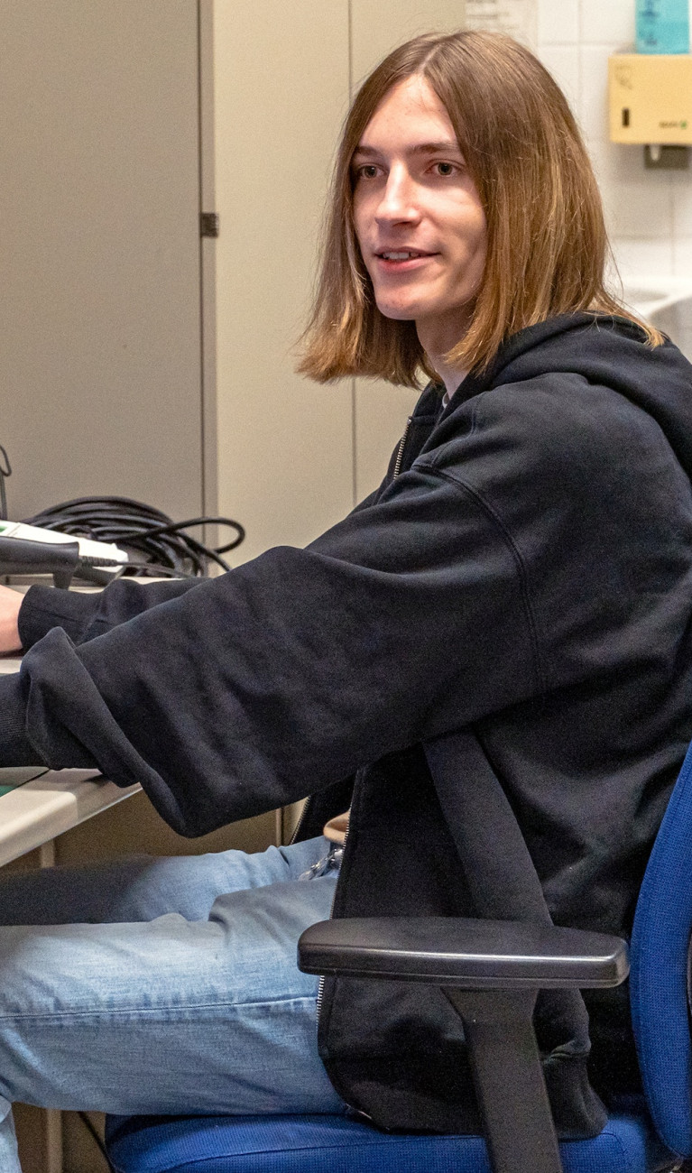 Ein junger Student sitzt vor einem Rechner