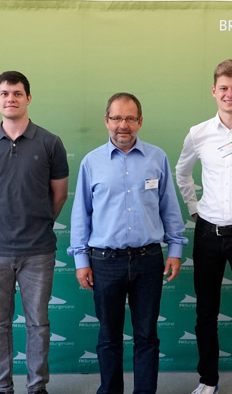 Drei Personen vor Banner e-nova Kongress