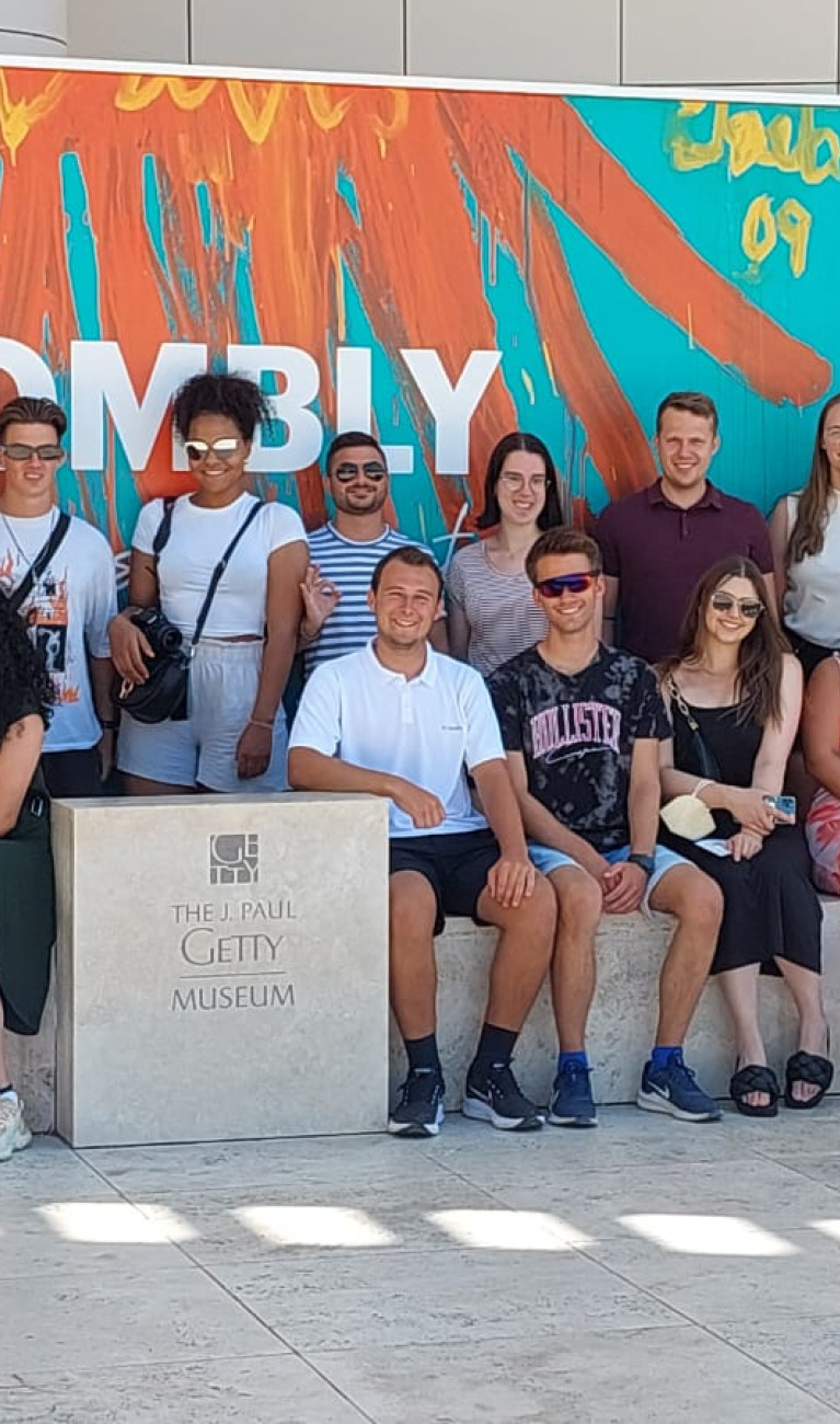 Gruppenbild vor buntem Plakat 