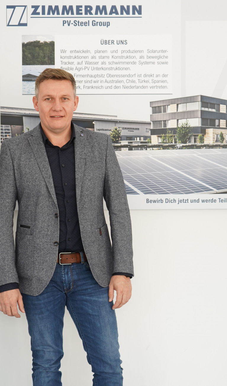 Drei Personen vor Logo PV Stahlbau