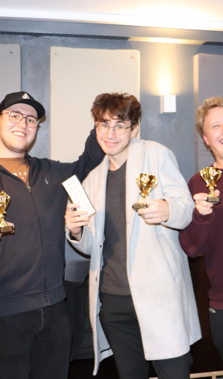 Drei Studenten mit Pokalen in der Hand, freuen sich über den Gewinn bei der KI Werkstatt Night