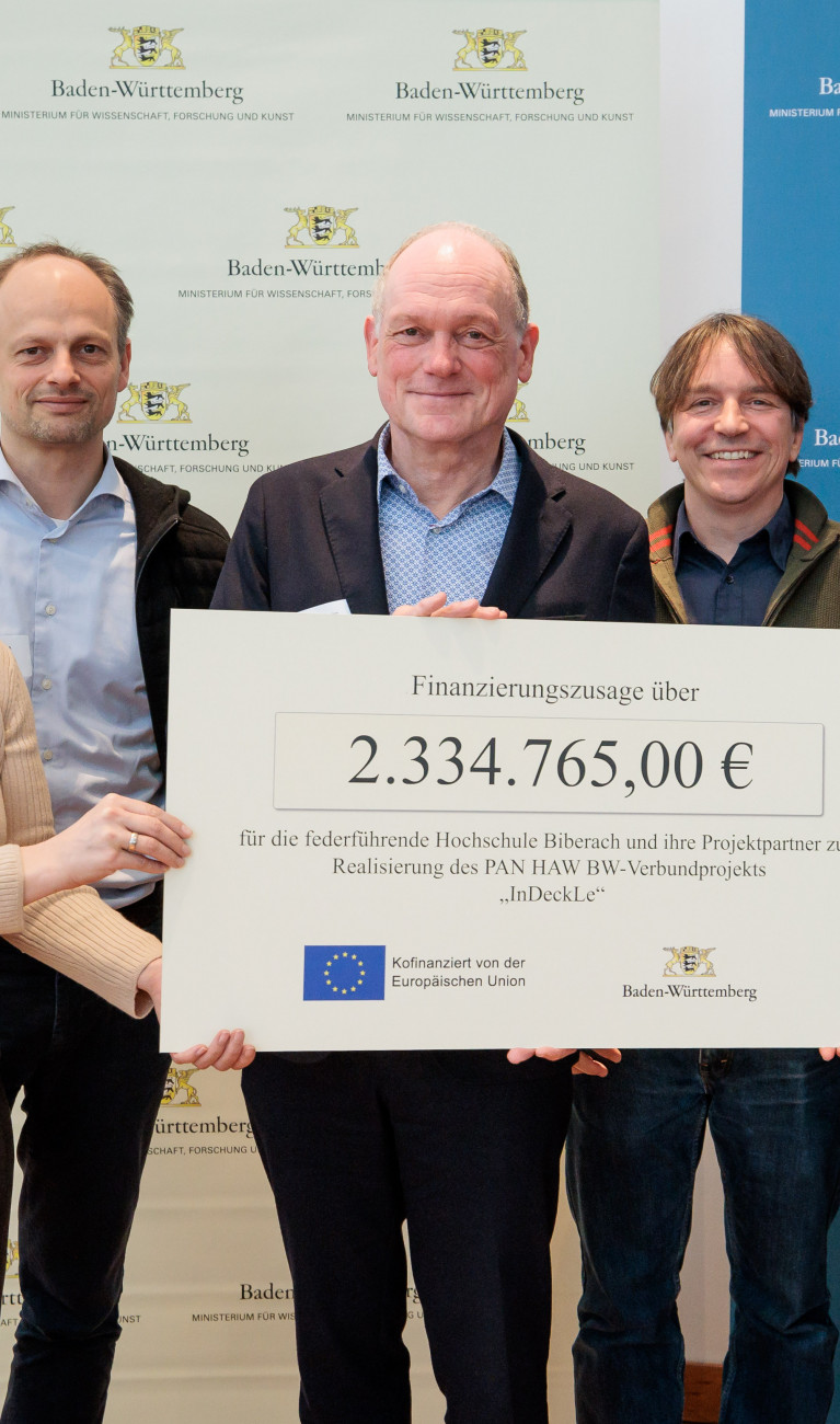 Sechs Personen halten Scheck hoch