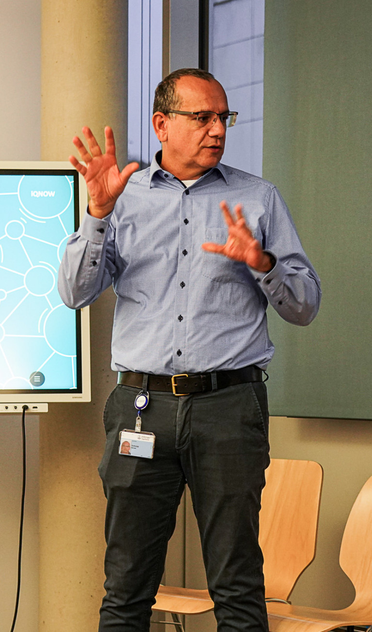 Mann steht vor einem Bildschirm und präsentiert