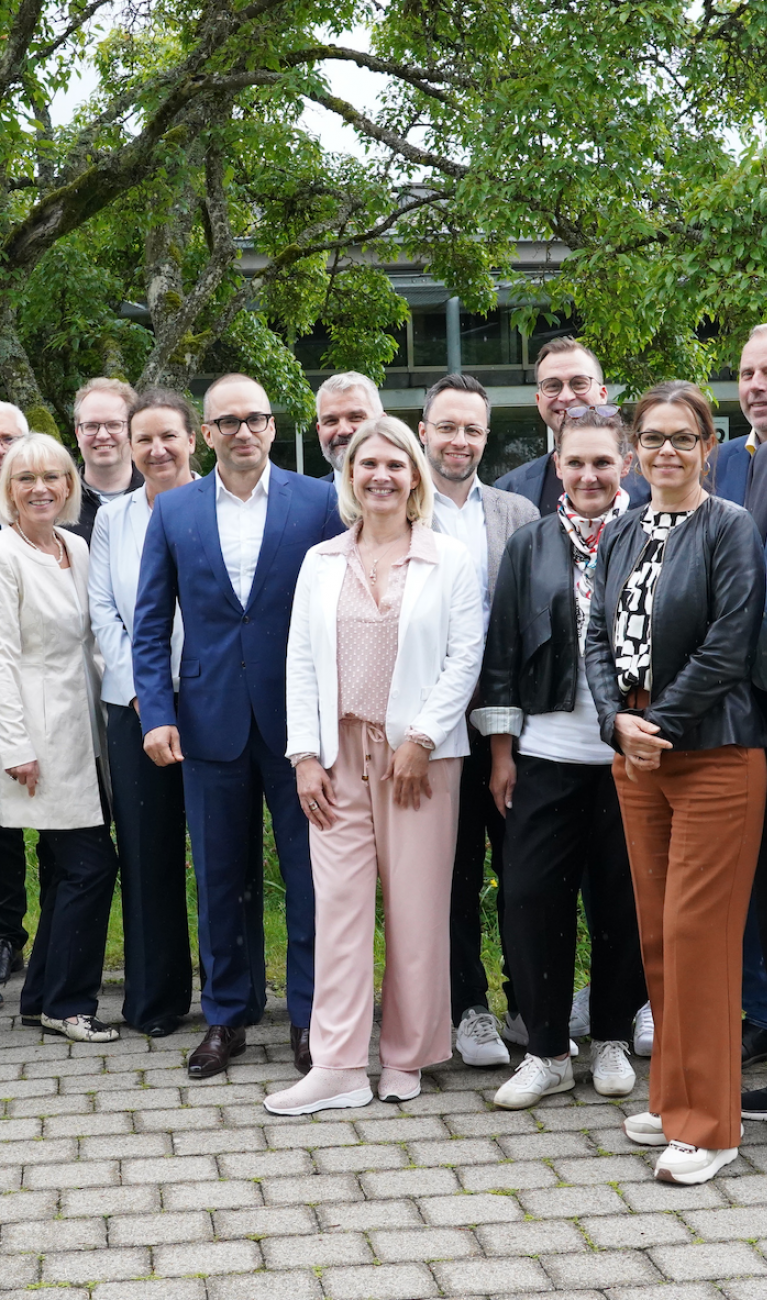 Viele Personen stehen draußen für ein Gruppenfoto