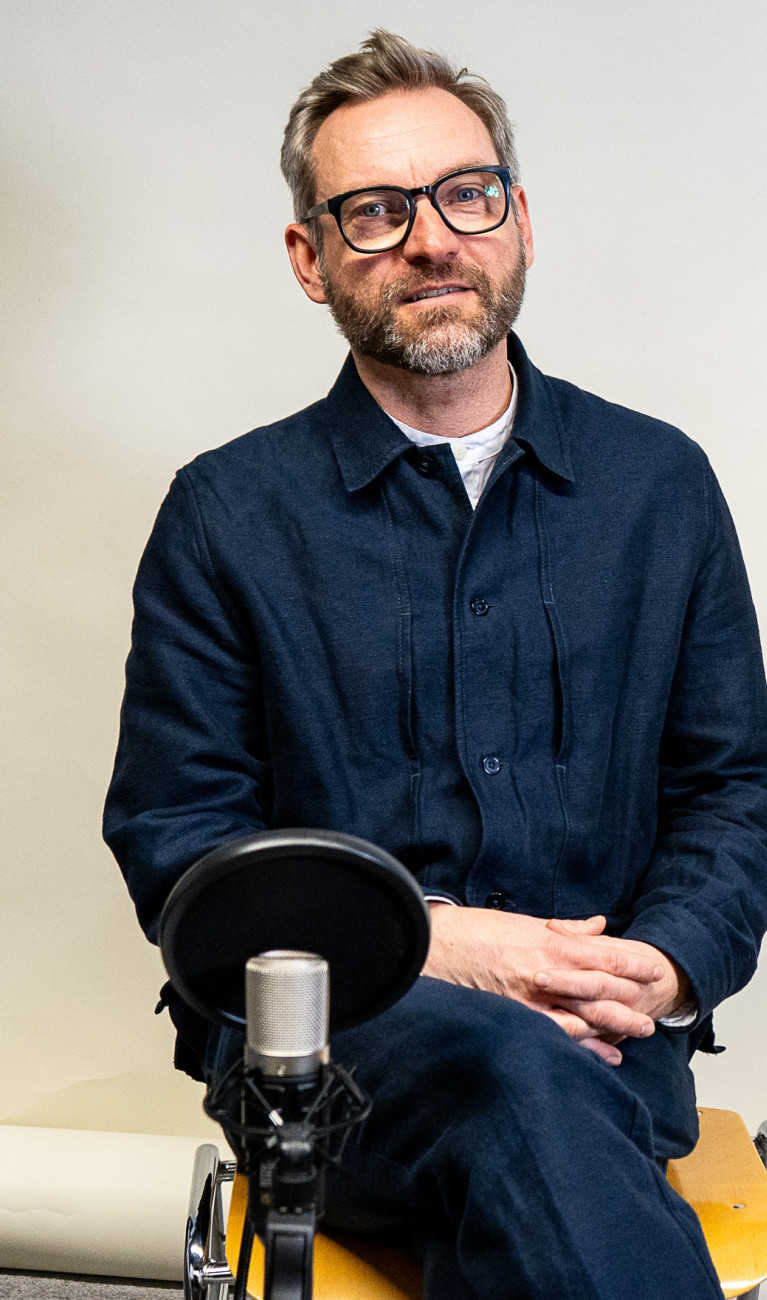 Ein Mann sitzt vor einem Mikrofon
