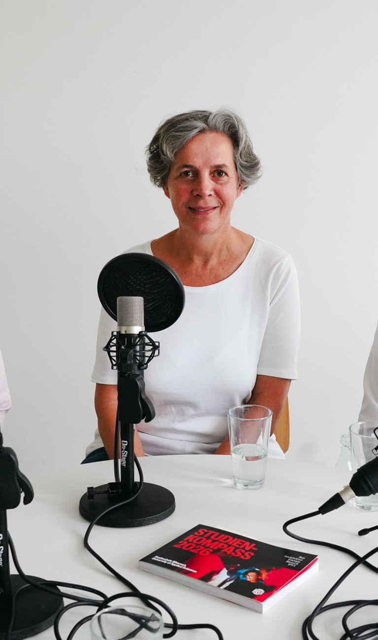 Drei Personen sitzen bei einer Podcast-Aufnahme