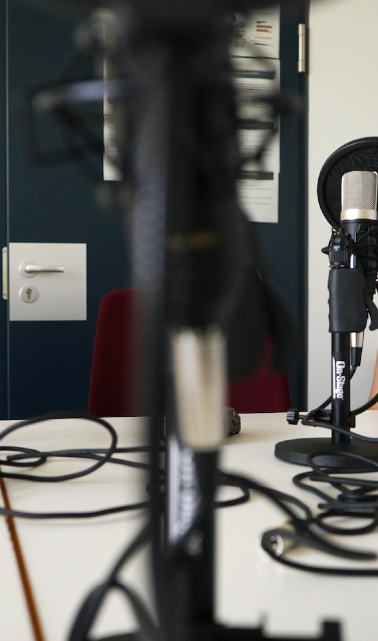 Zwei Frauen sitzen am Mikrofon bei Podcastaufnahme