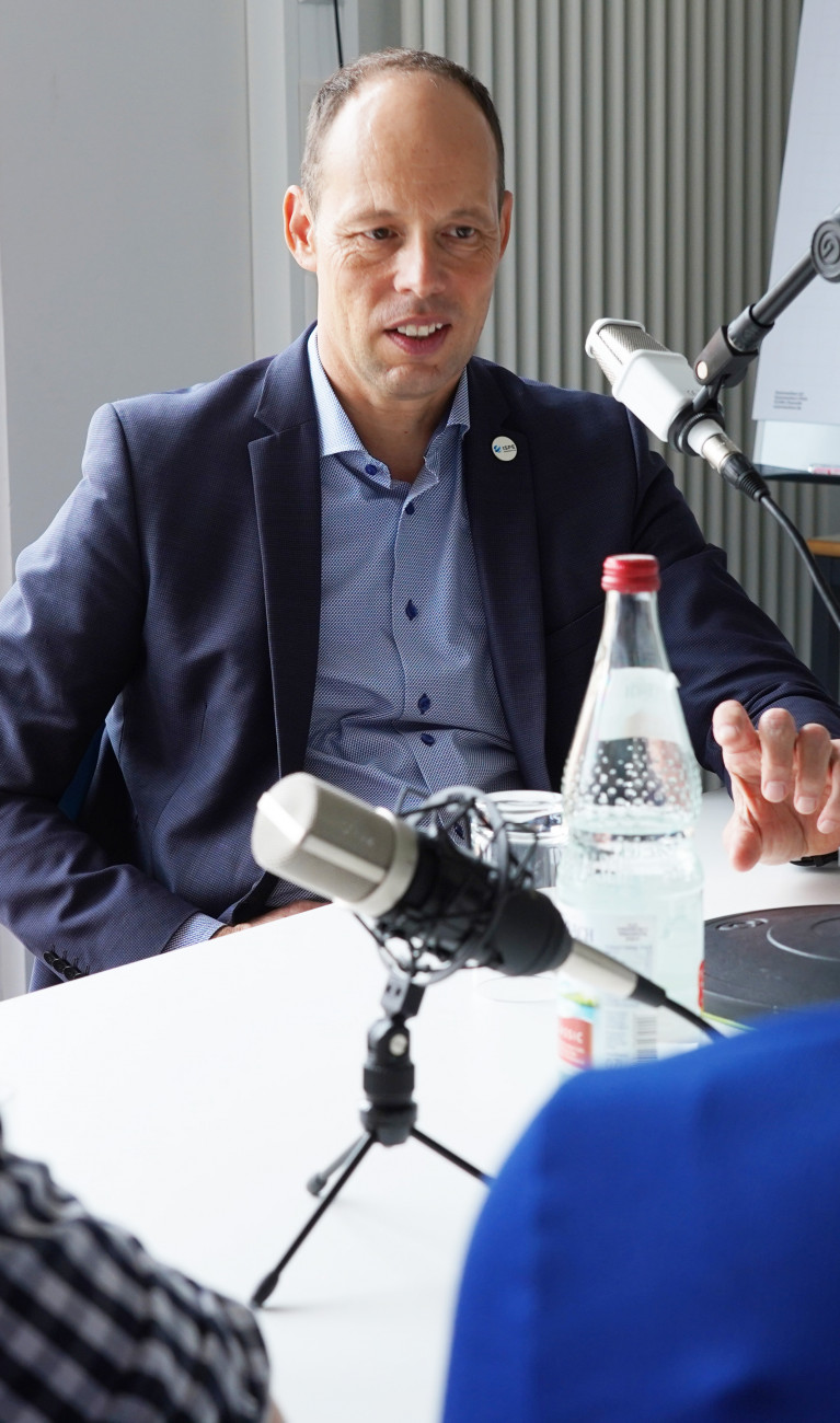 Mann bei Podcastaufnahme