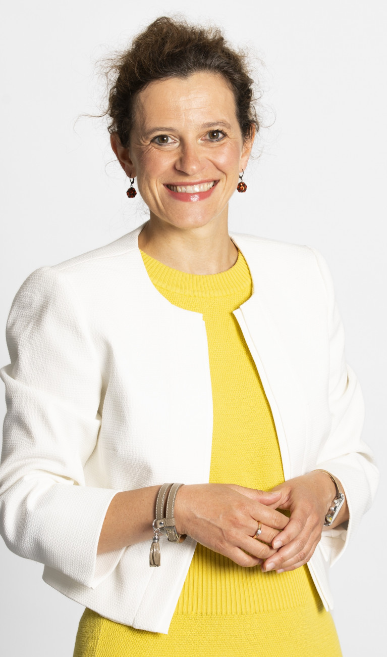Frau im Porträt mit gelbem Shirt und weißem Blazer