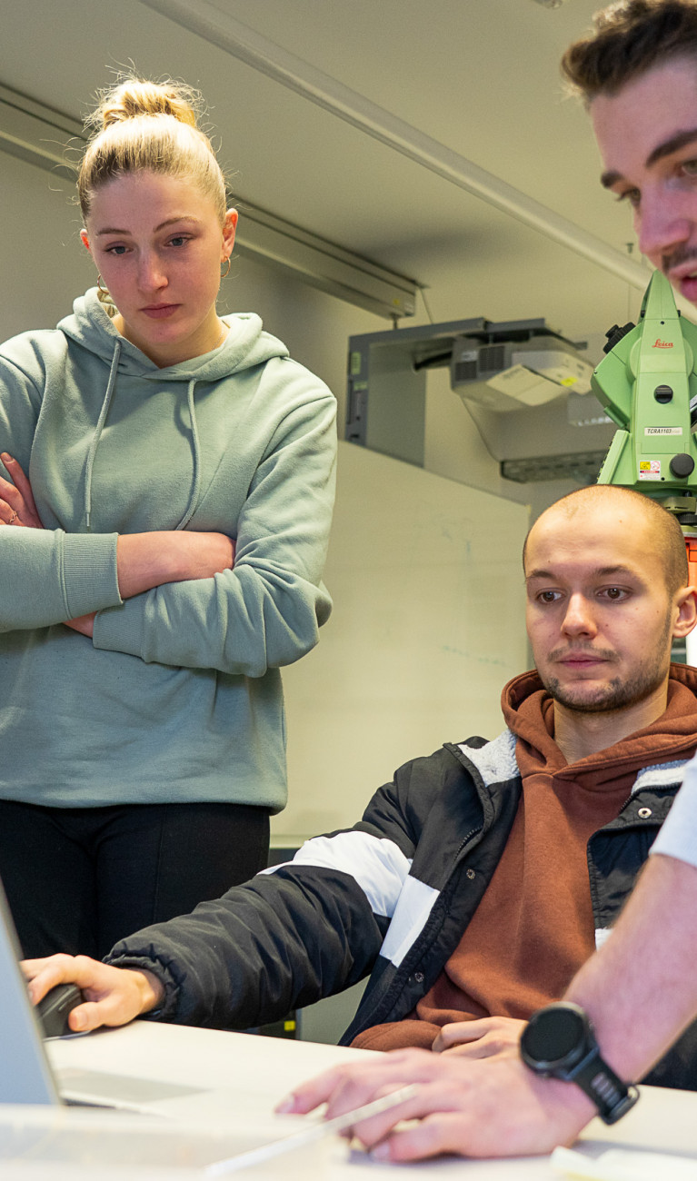 Vier Studierende arbeiten an einem Laptop