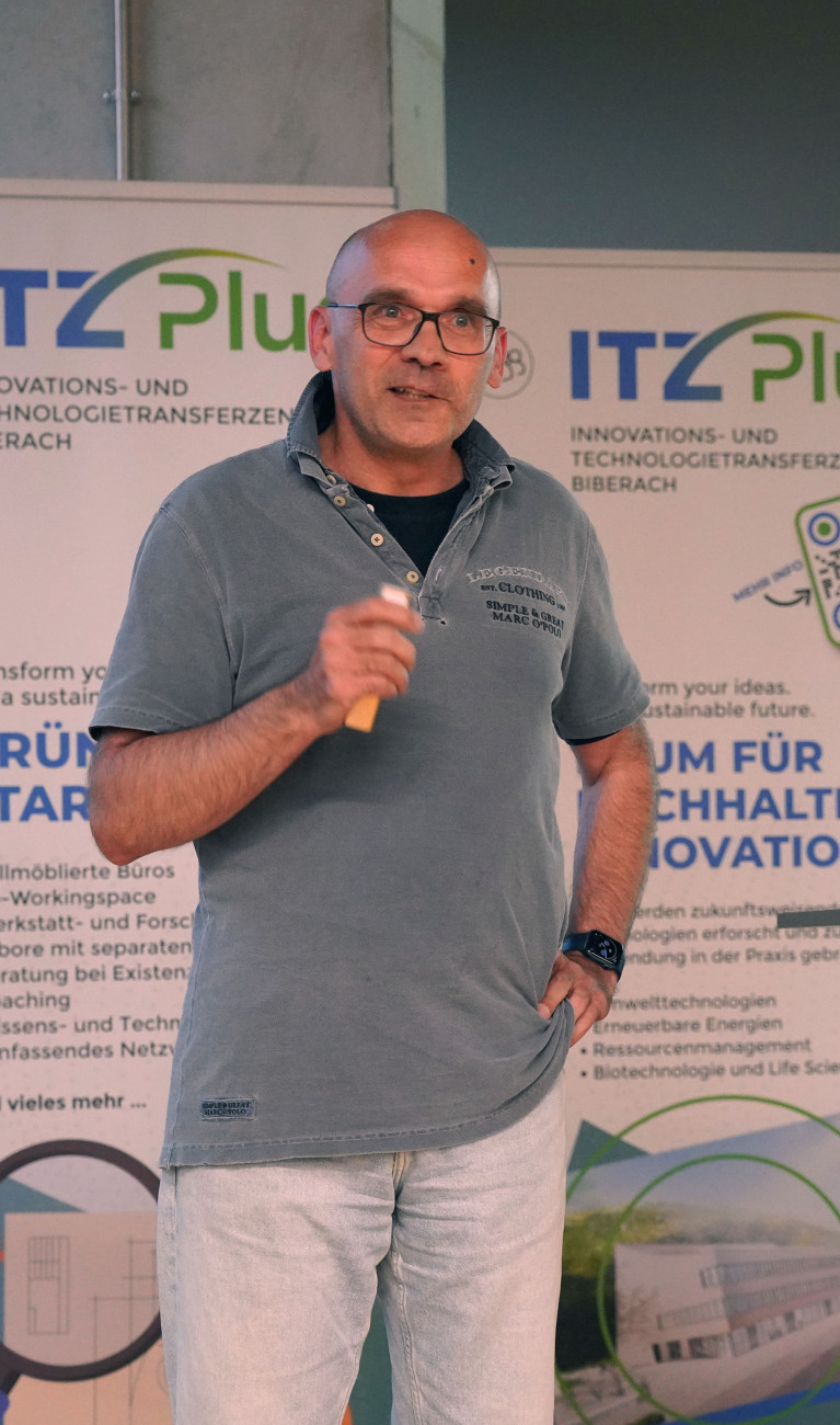 Mann mit Mikrofon hält Vortrag