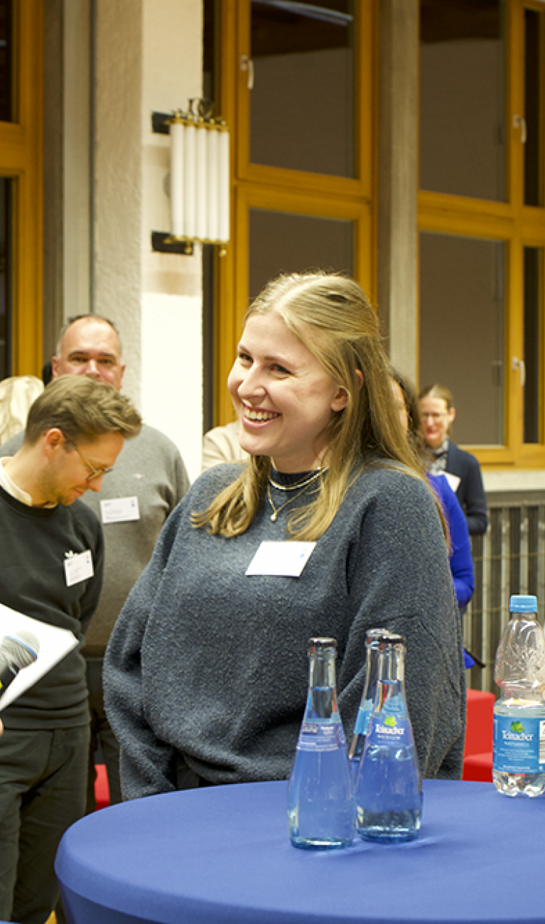 Mann übergibt Urkunde an Studentin