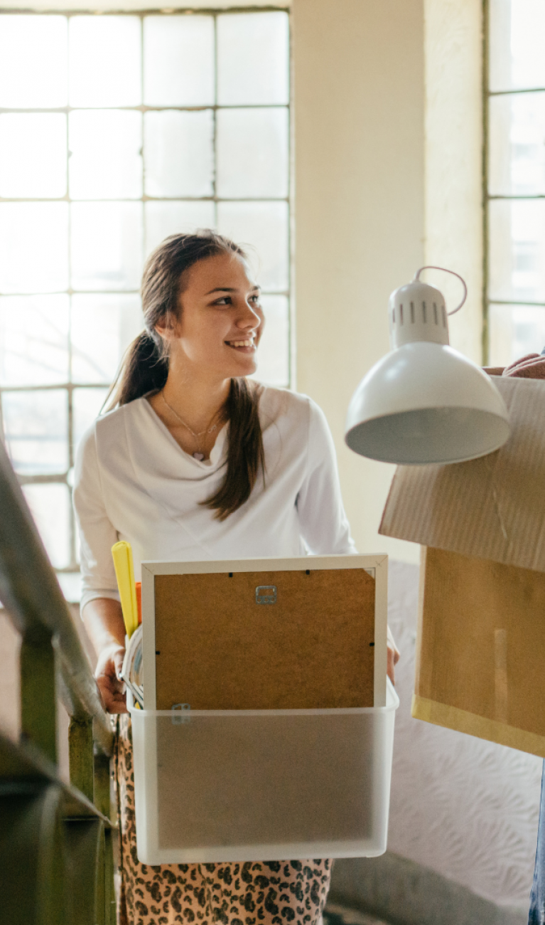 Zwei Frauen tragen Umzugskartons 