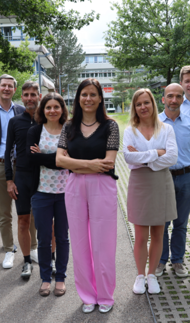 Personen stehen draußen für ein Gruppenfoto