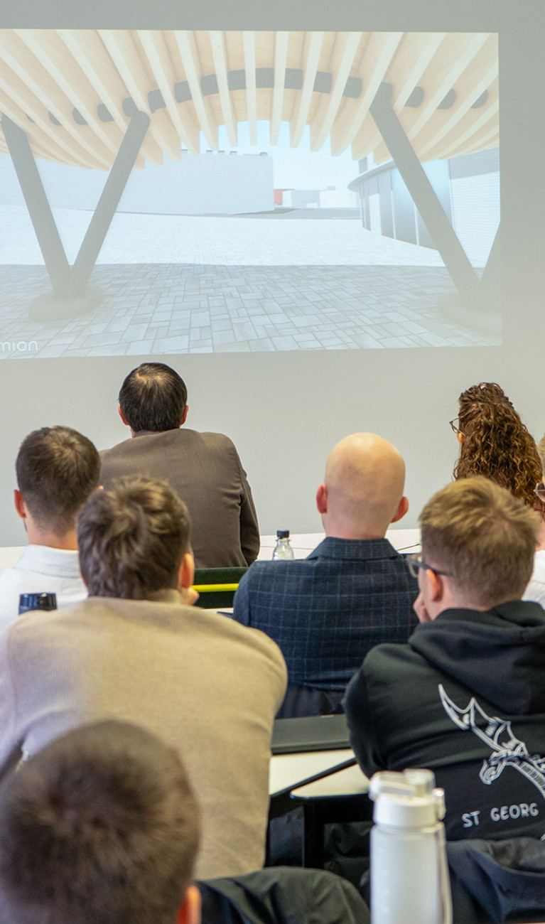 Studierender des Bau-Projektmanagement präsentiert seinen Entwurf im Plenum