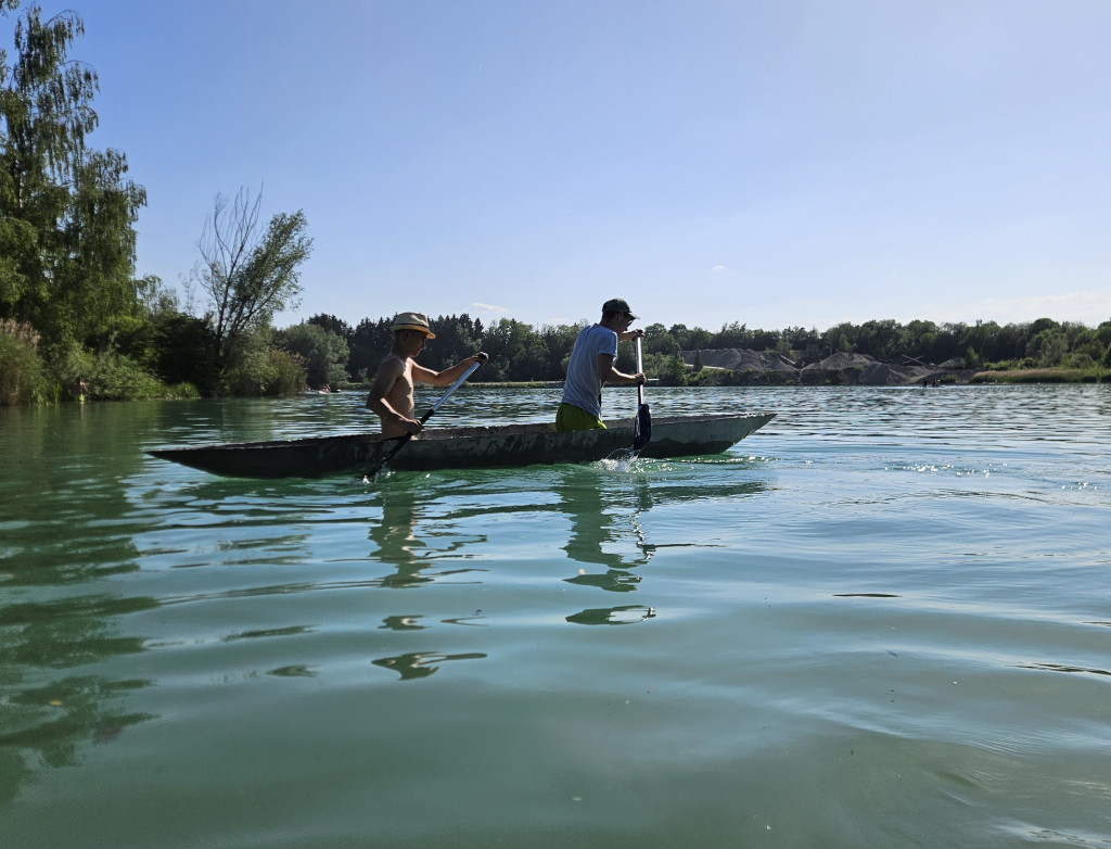 Zwei Männer in einem Betonkanu auf dem See
