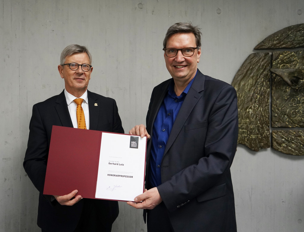 Übergabe Urkunde zwischen zwei Männern