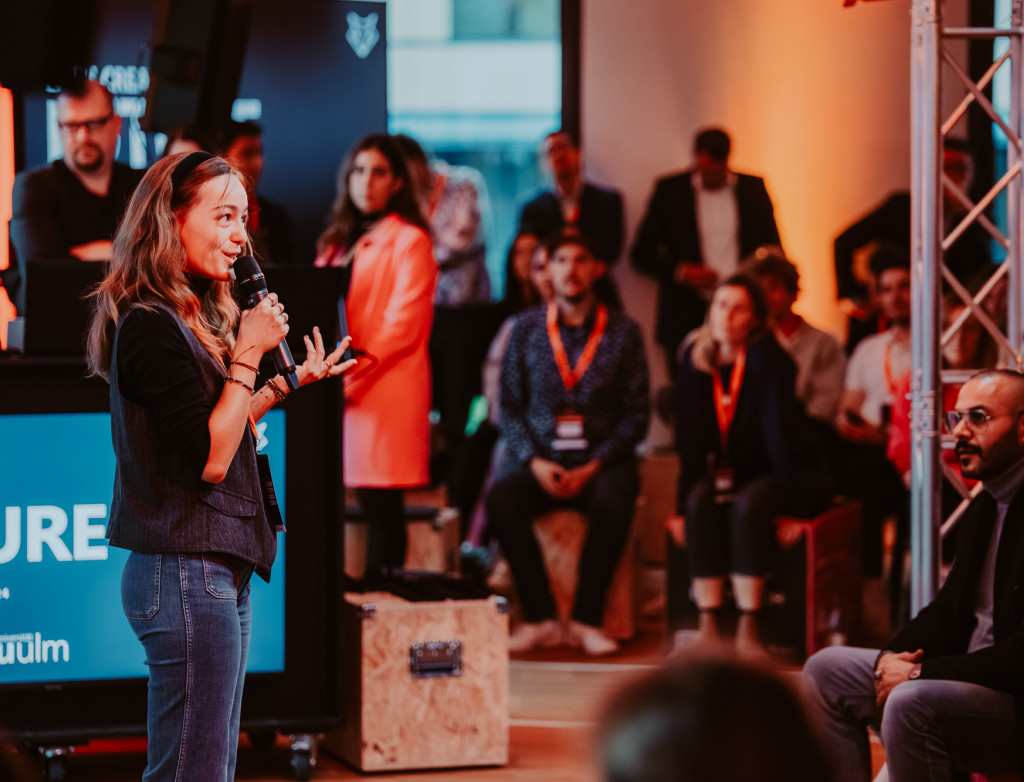 Eine Frau steht auf einer Bühne und präsentiert