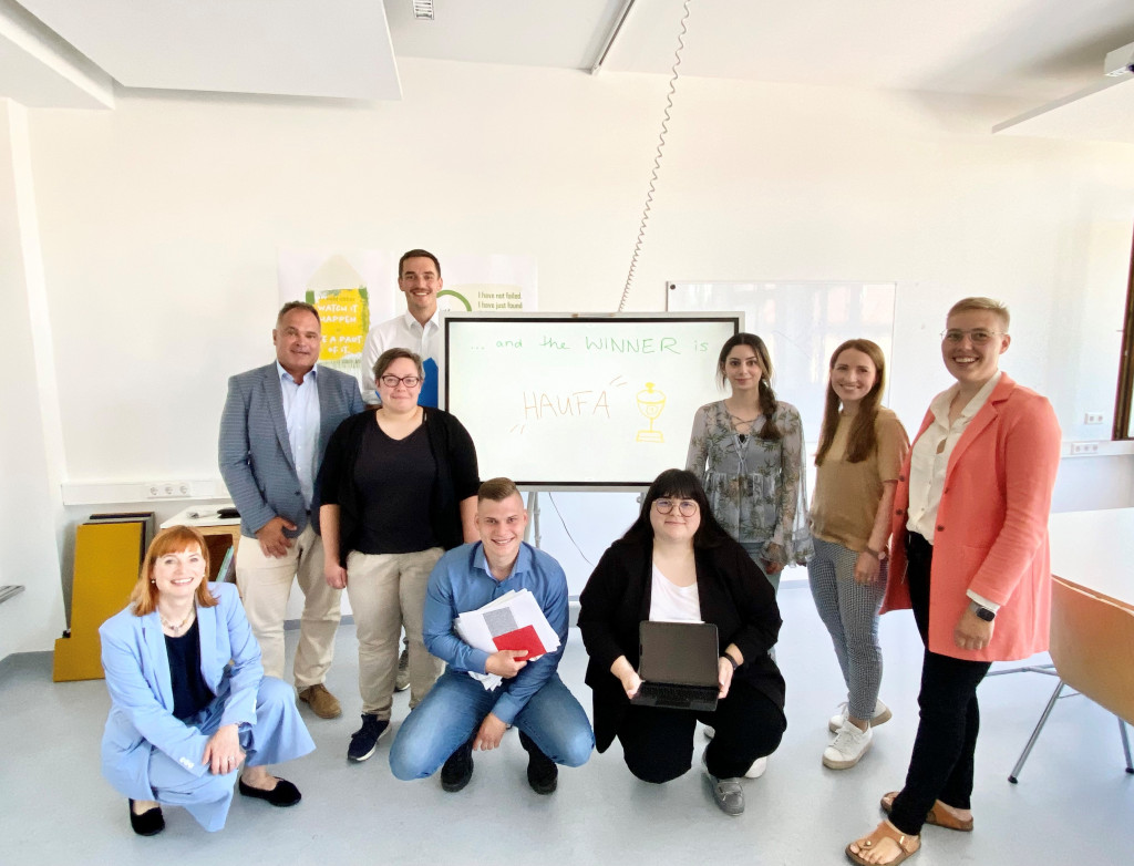 Neun Menschen verteilt vor einem Whiteboard