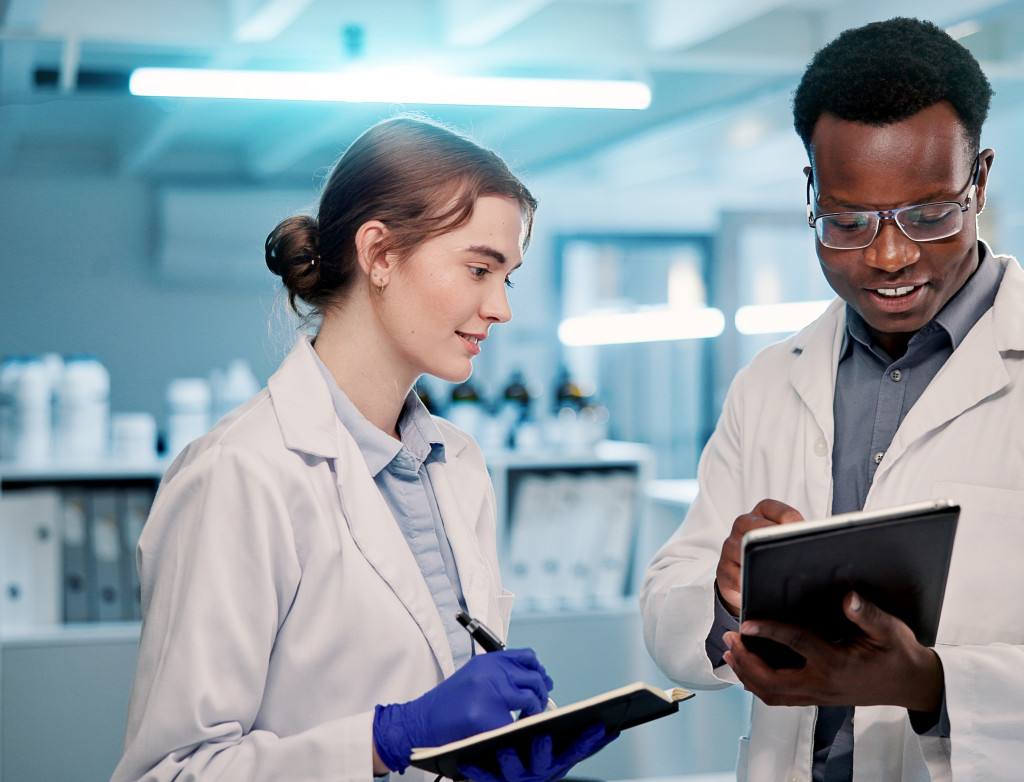 Ein Mann und eine Frau stehen im Labor mit Tablets in der Hand