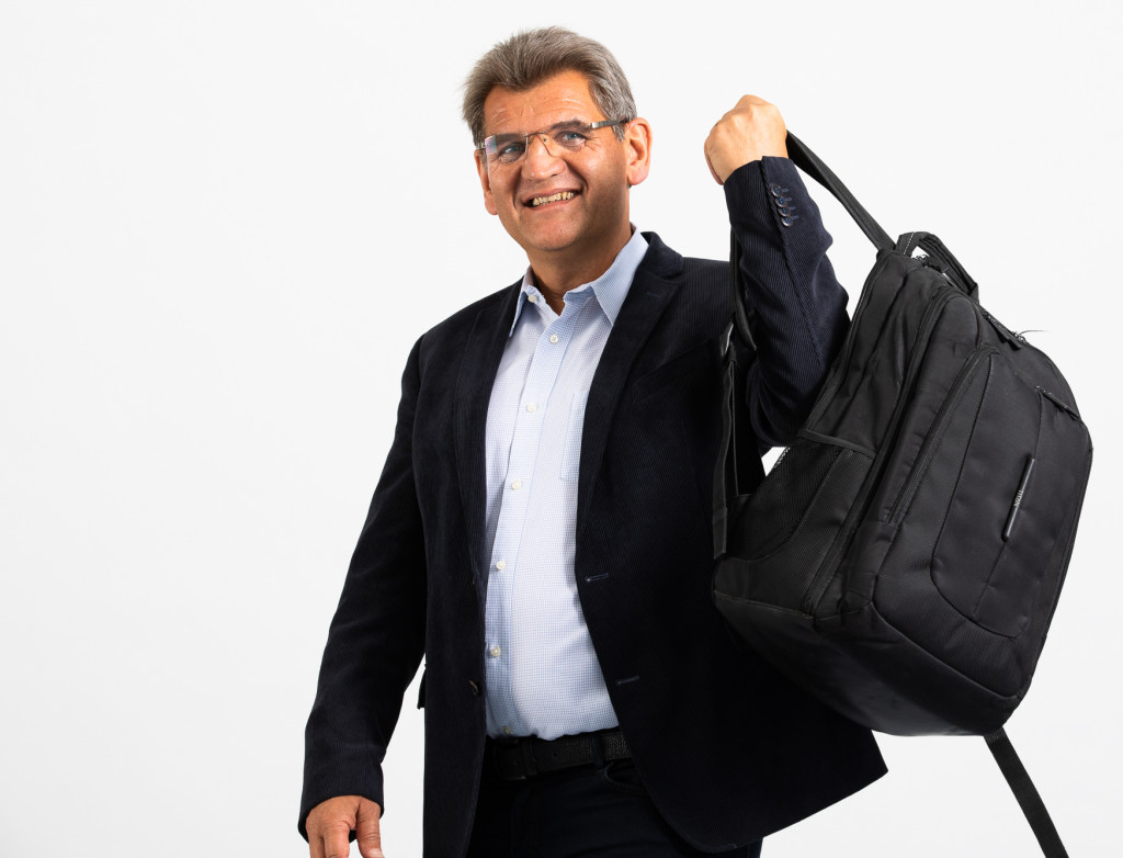 Mann schwingt Rucksack über seinen Rücken