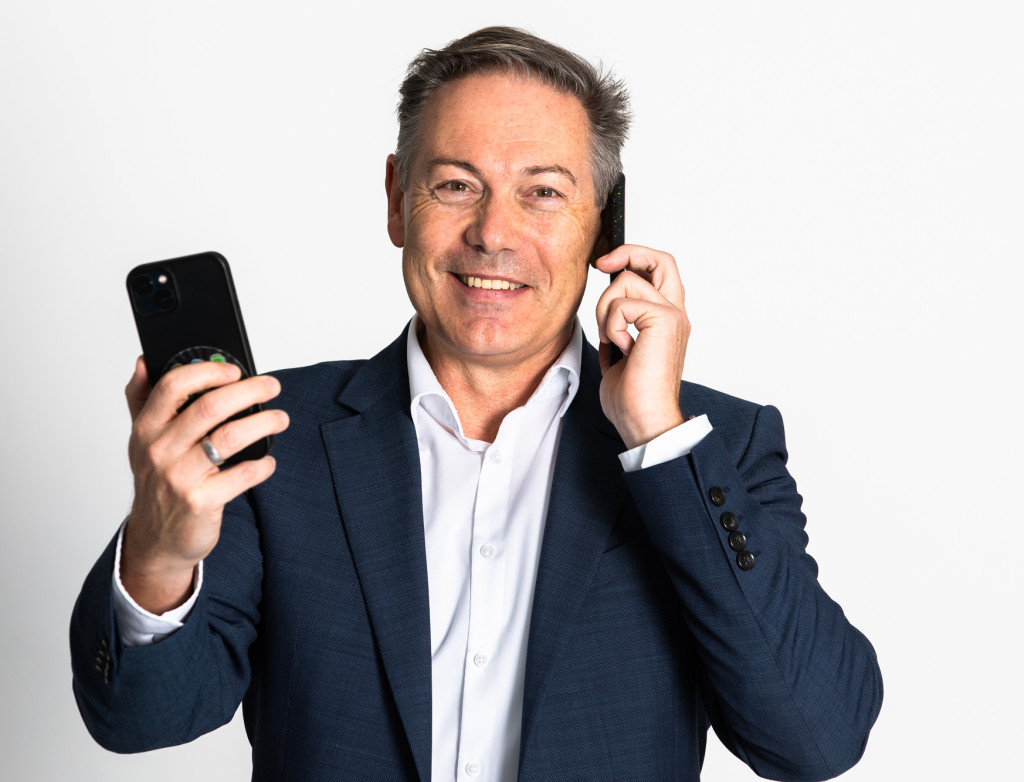 Porträt Mann mit zwei Handys in der Hand