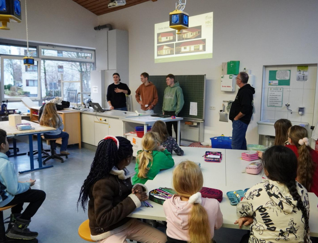 Kinder sitzen in der Schule und planen ein Gebäude