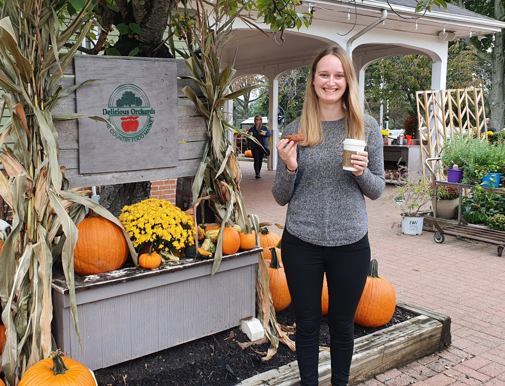 Junge Frau vor einem Kürbisstand in Amerika