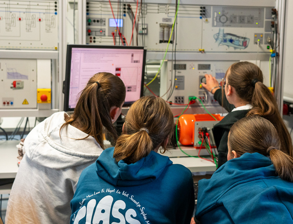 Schülerinnen sitzen vor einem Computer