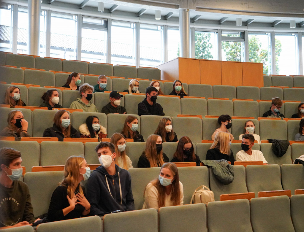 Studierende in großem Hörsaal mit Masken