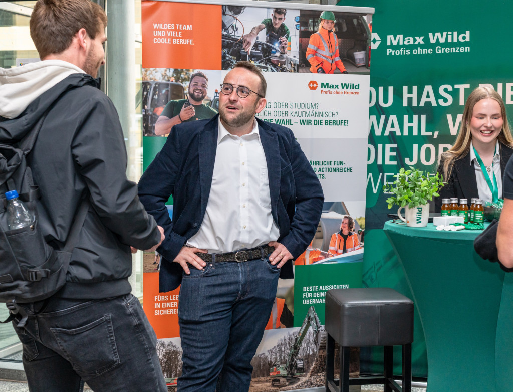 Menschen stehen an einem Messestand und lassen sich beraten