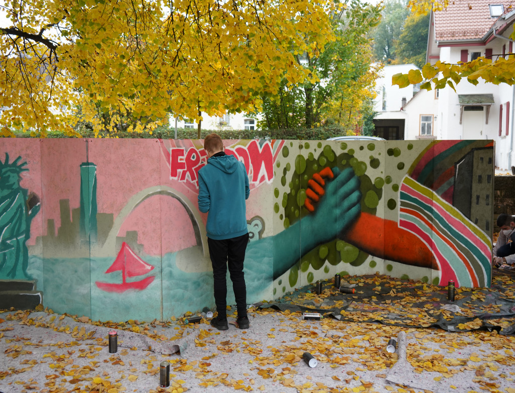 Mann von hinten beim Graffiti sprühen