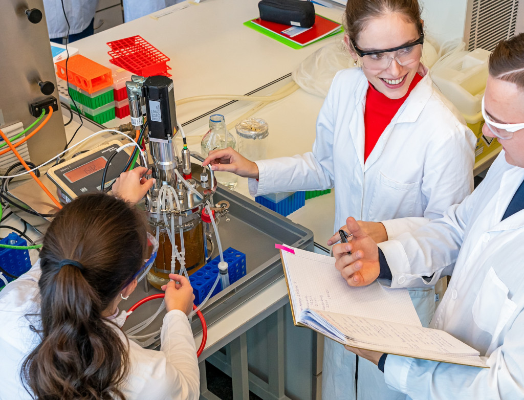 Drei junge Menschen beim Versuch im Labor