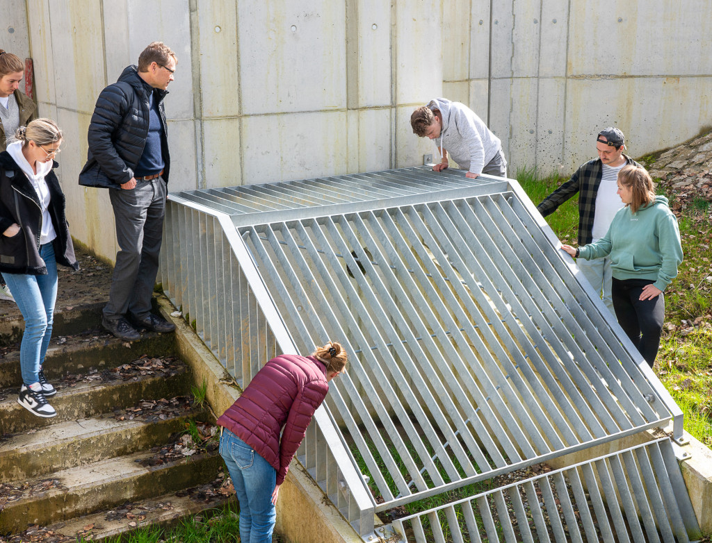 Studierende schauen in einen Schacht draußen