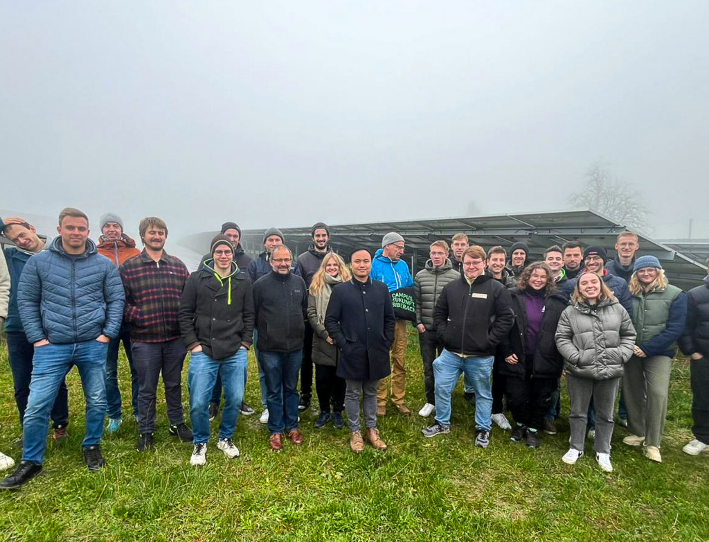 Großes Gruppenbild draußen bei einer PV-Anlage