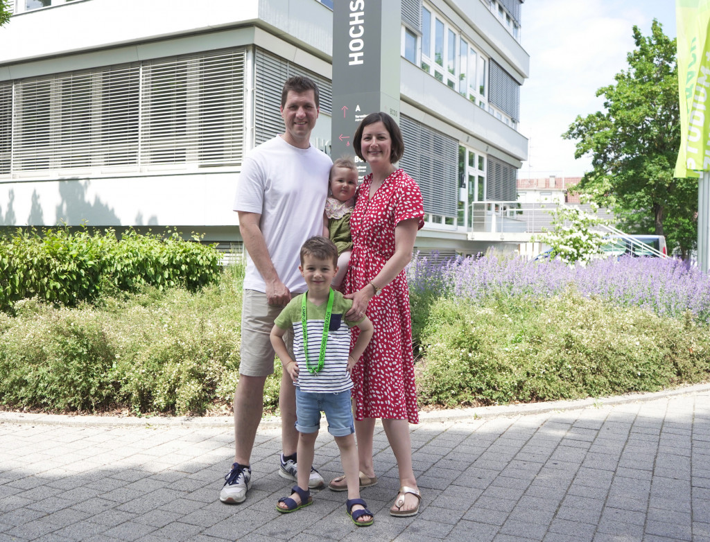 Mann, Frau und zwei Kinder vor Gebäude