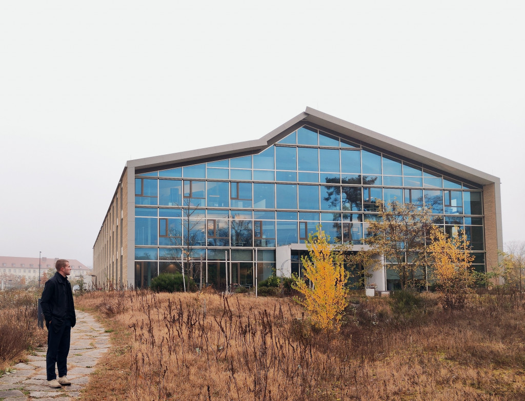 Ein modernes Haus mit viel Glas, ein Student steht davor