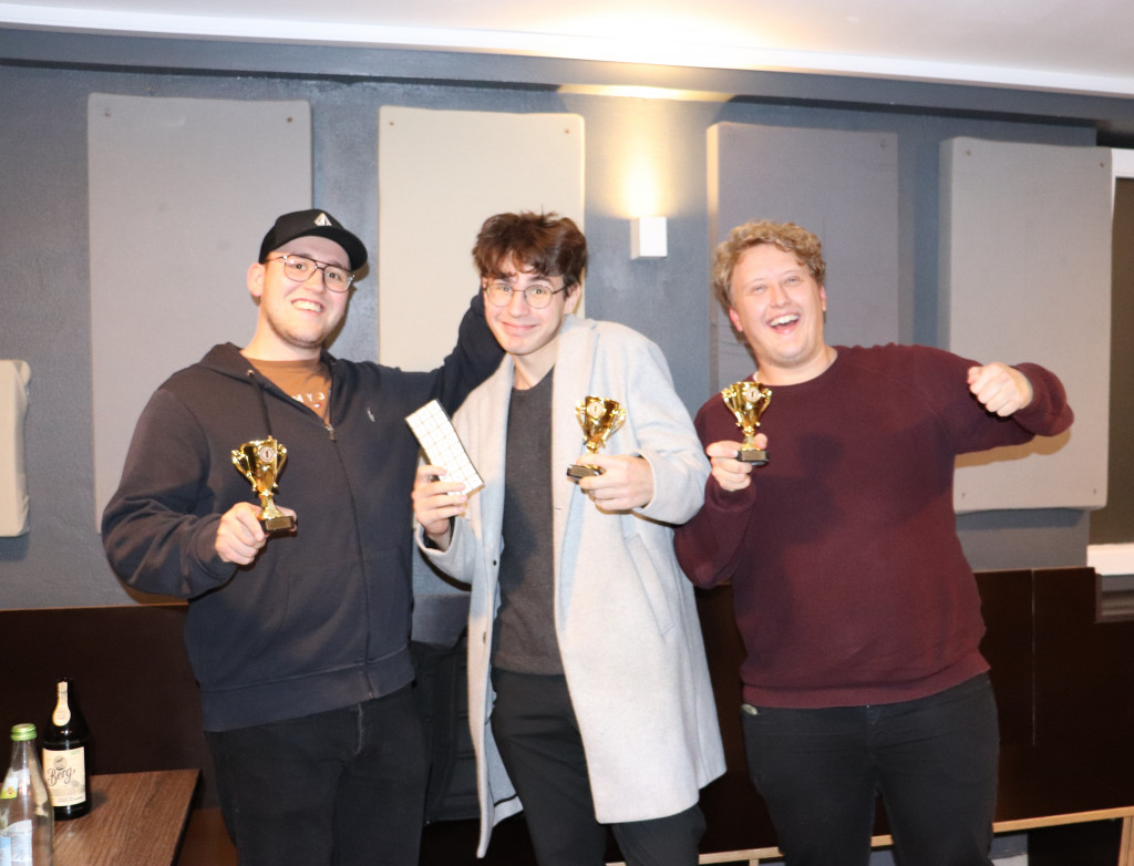 Drei Studenten mit Pokalen in der Hand, freuen sich über den Gewinn bei der KI Werkstatt Night