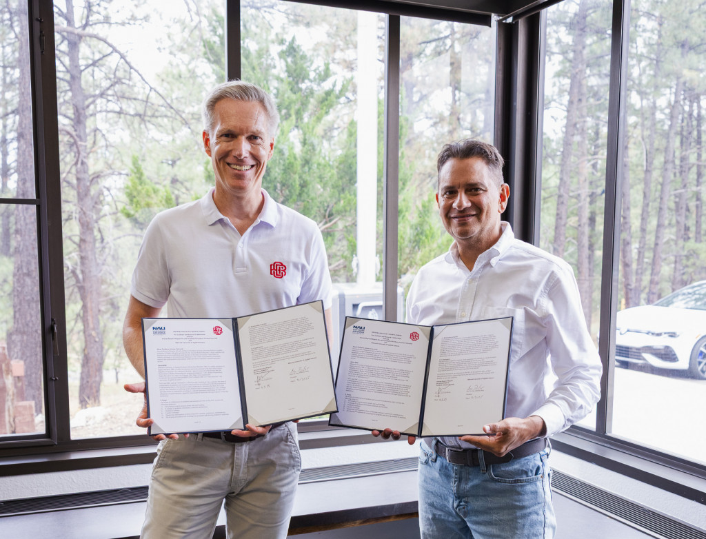 Zwei Männer präsentieren unterschriebene Verträge