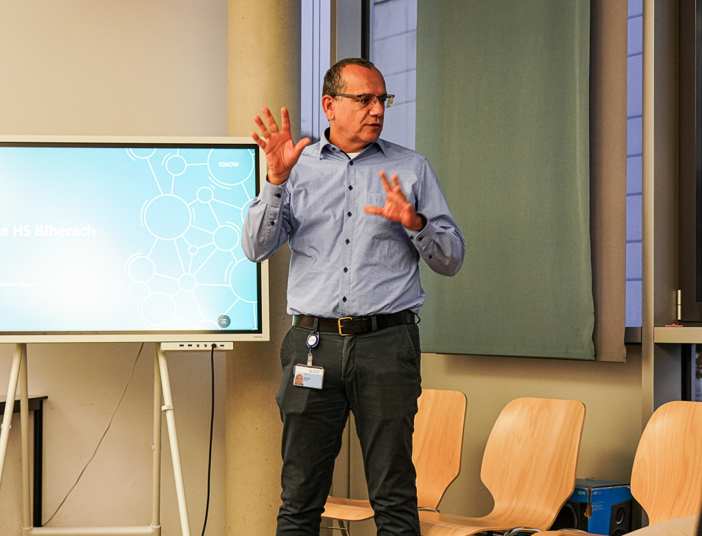 Mann steht vor einem Bildschirm und präsentiert