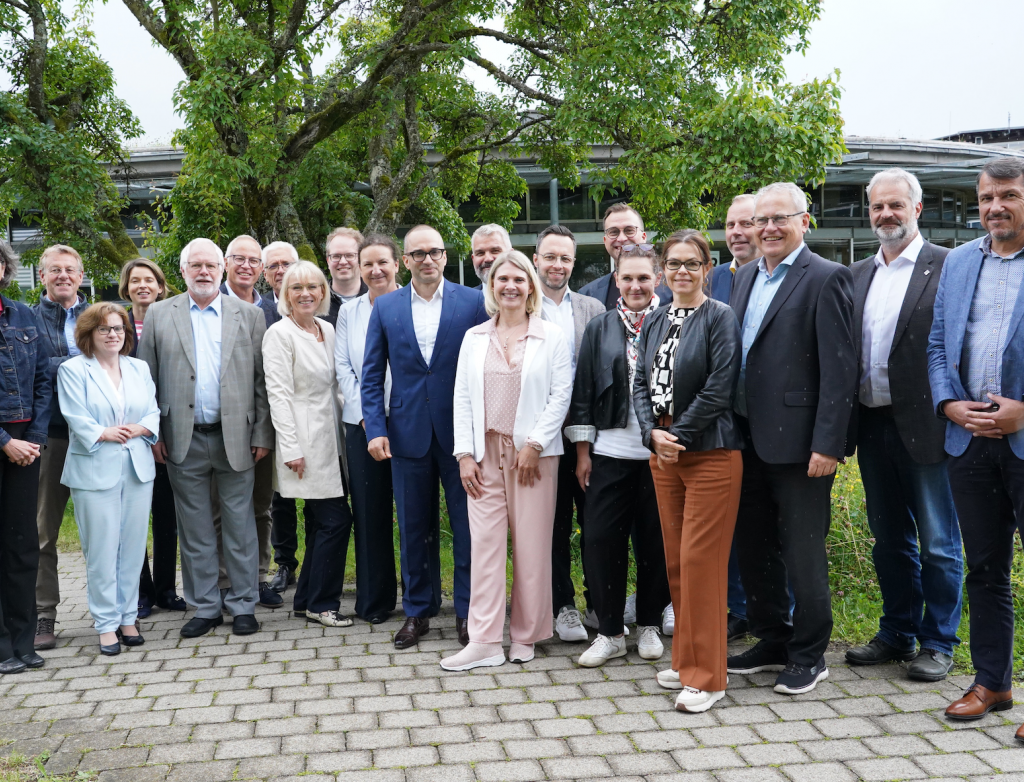 Viele Personen stehen draußen für ein Gruppenfoto