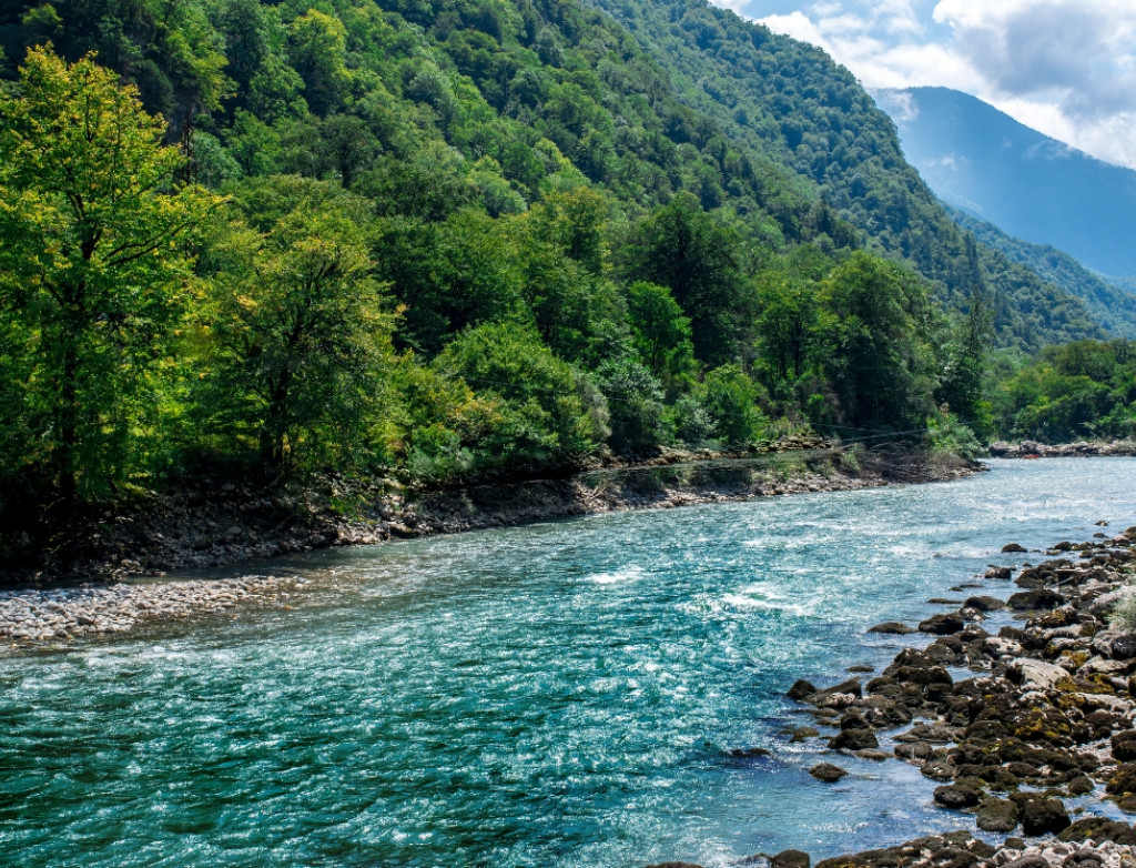 Ein klarer Fluss fließt durch eine Berglandschaft